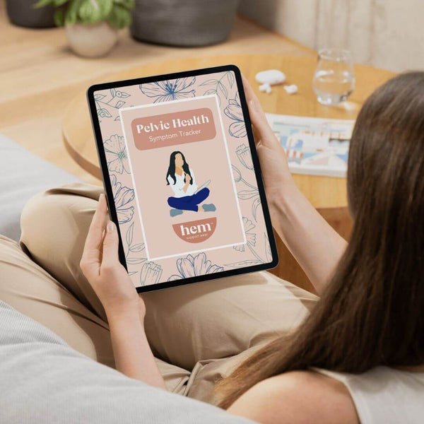Person using a tablet with the pelvic health symptom tracker on a couch
